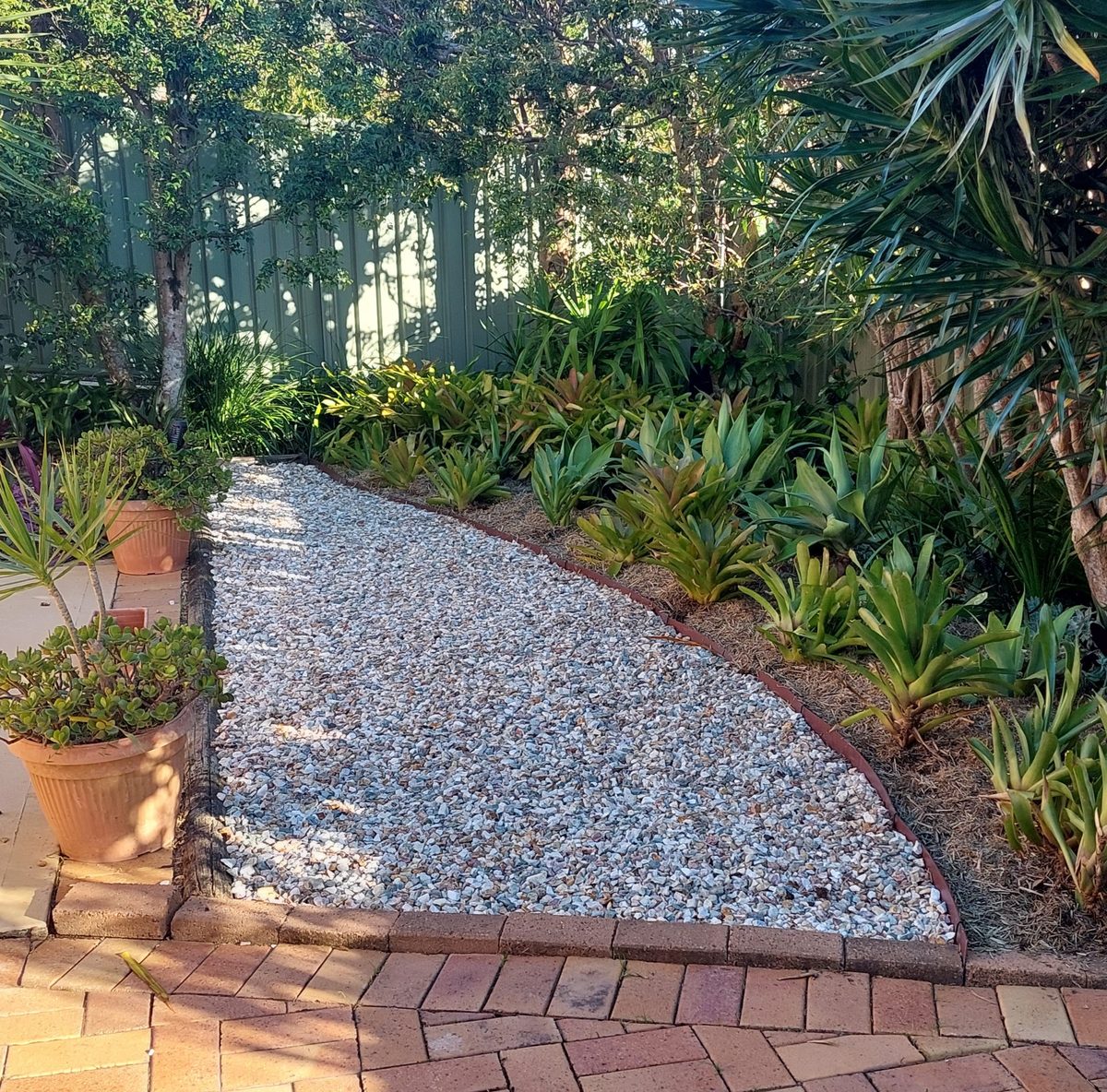 The same strip converted to a gravel path with fresh garden beds